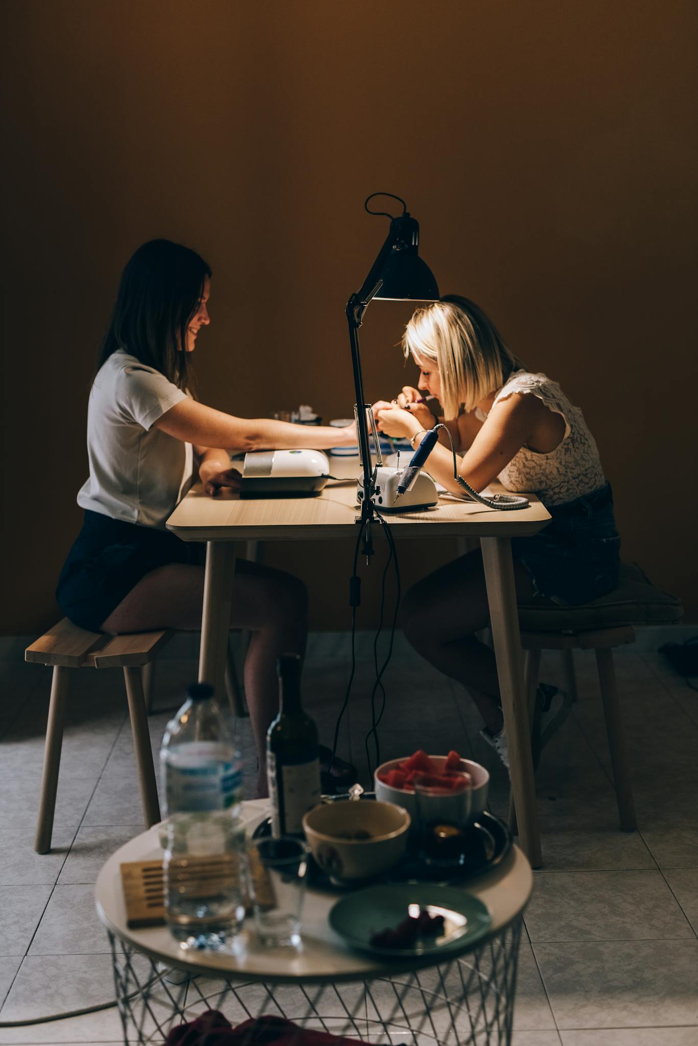 A nail technician providing a manicure to a client in a cozy salon setting. Focus on professionalism and care.
